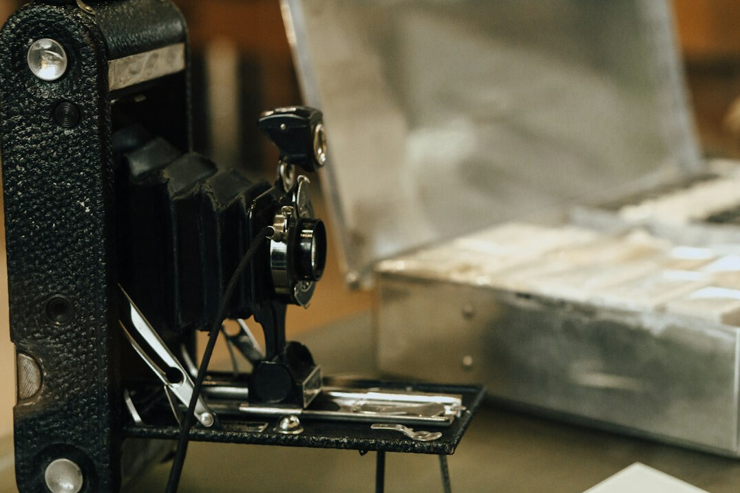 Vintage photo archive desk with contact sheets, magnifying loupe and old camera