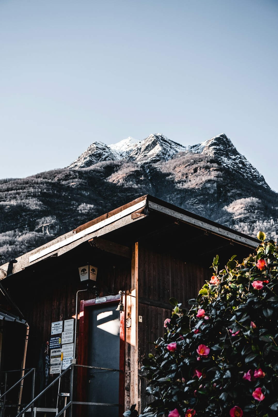 Traditional Swiss alpine chalet exterior with wooden facade and snow-capped mountains